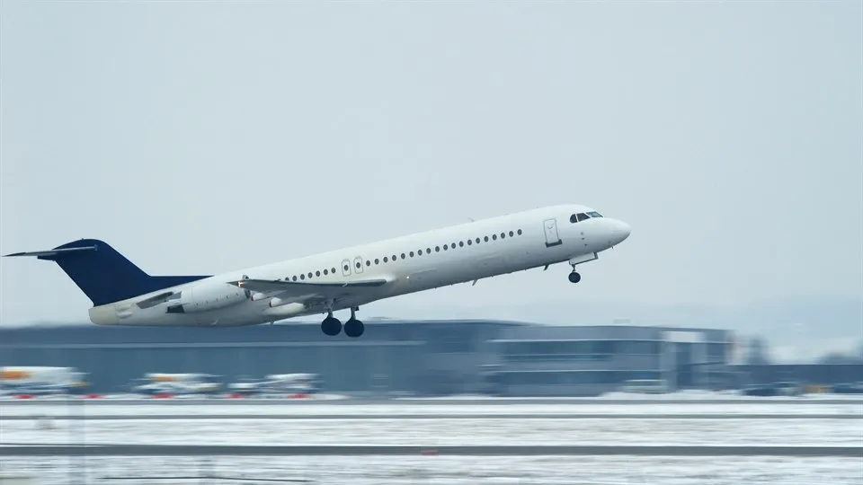 Flygplan på väg att lyfta från en vintrig flygplats.