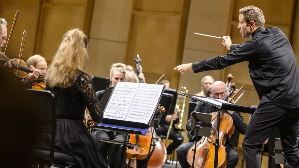 man in shirt conducting orchestra