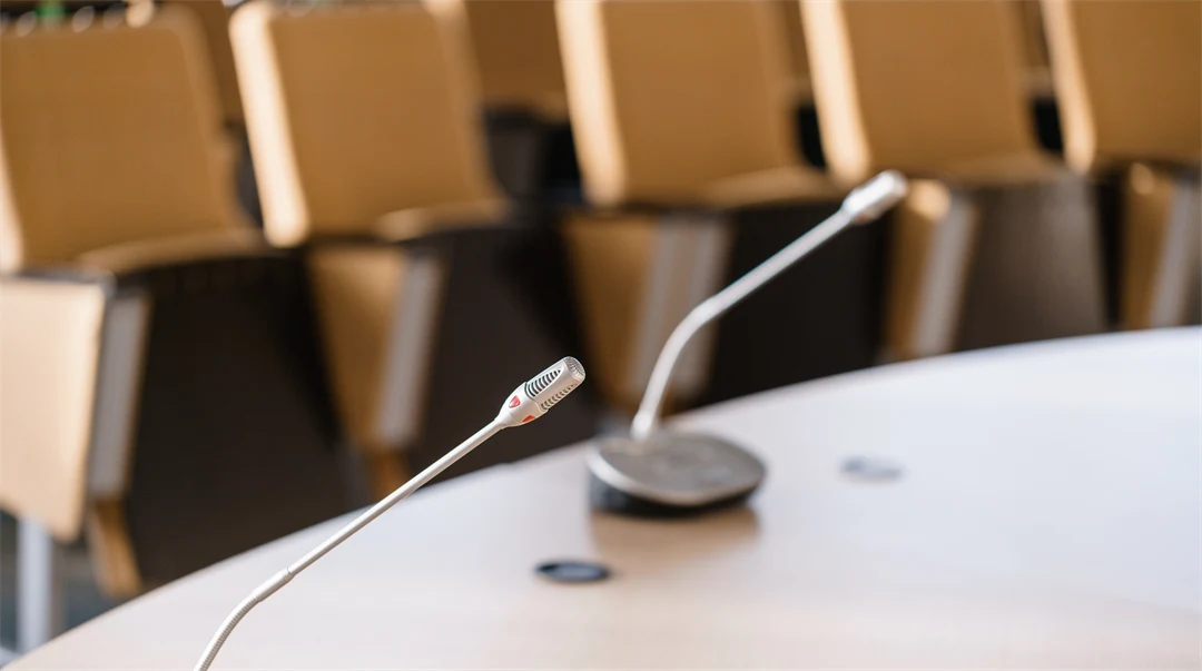 Two microphones standing on a table in a lecture room