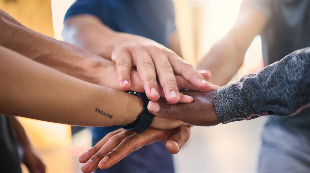 Kontorsanställda grupp med händer in för att visa samarbete, förtroende och motivation för företagets jobbframgång.