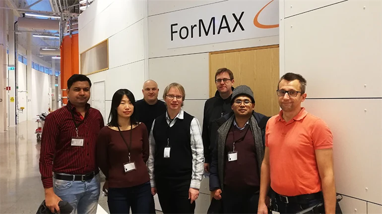 Group photo with researchers standing in front of a sign that says ForMAX.