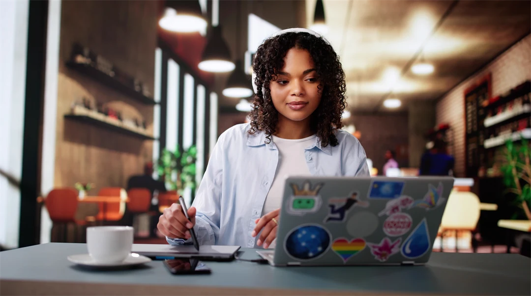 En ung mörkhårig kvinna sitter framför en laptop