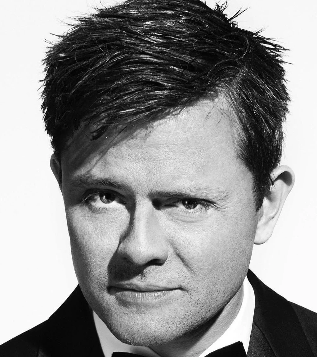 en man ler och tittar in i kameran