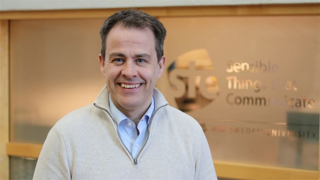 En man med mörkt hår och vit tröja