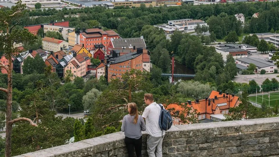 Två personer tittar på utsikten över Campus Sundsvall från Norra berget.