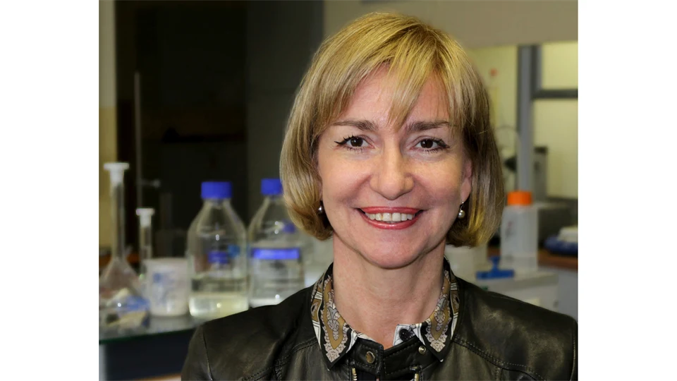 A woman with blond hair, dressed in a shirt and jacket.