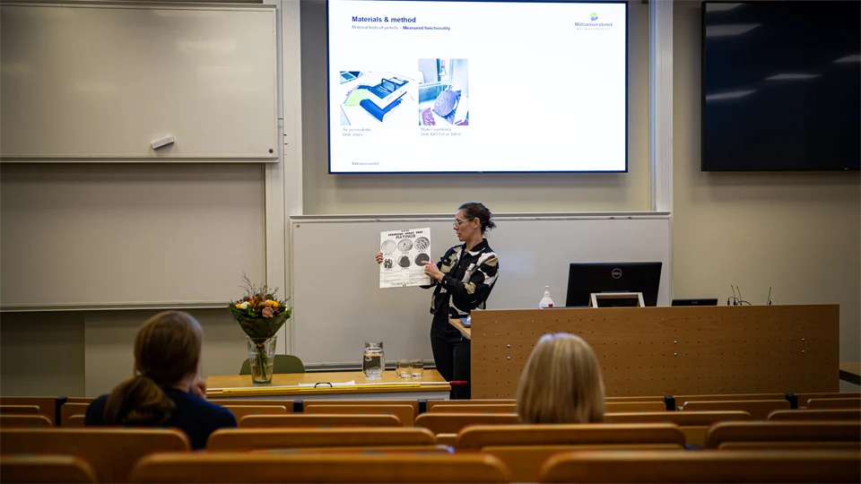 A woman stands in a classroom.