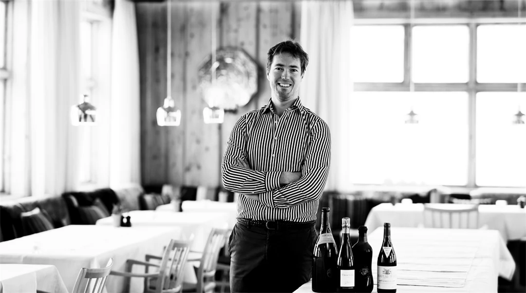 Svartvit bild på en man som står i en restaurang.