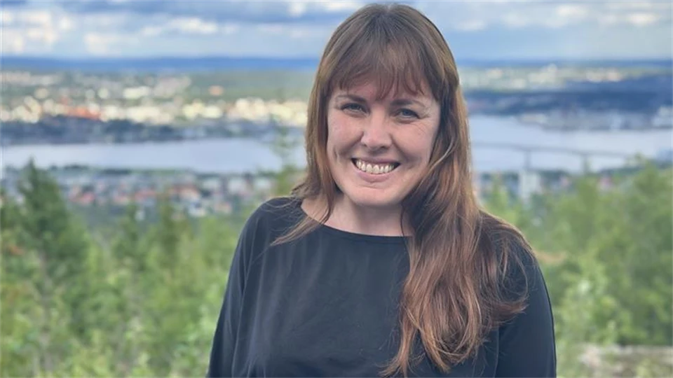 Kvinna med långt brunt hår och en svart tröja