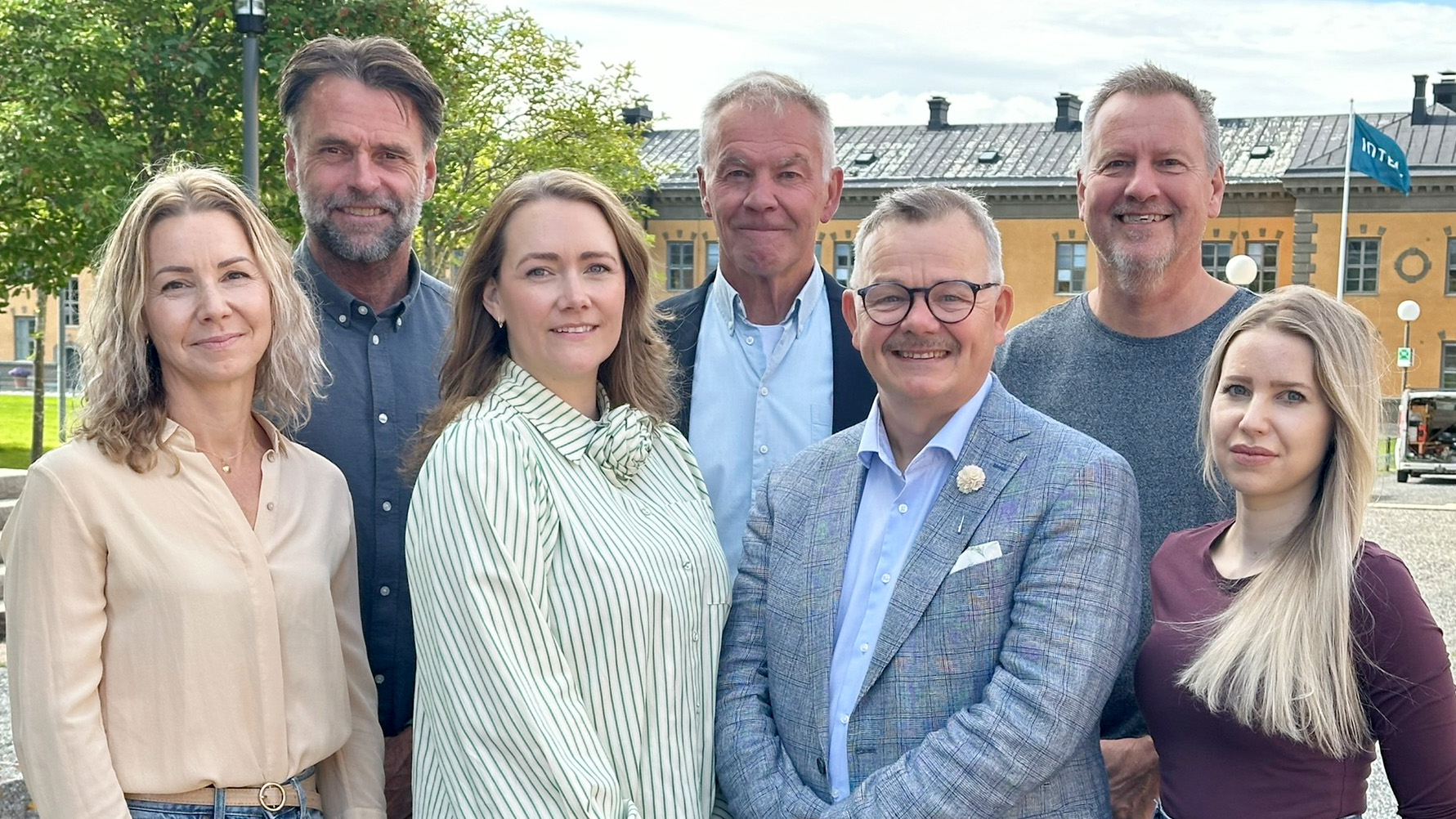 En gruppbild med sju personer utomhus.