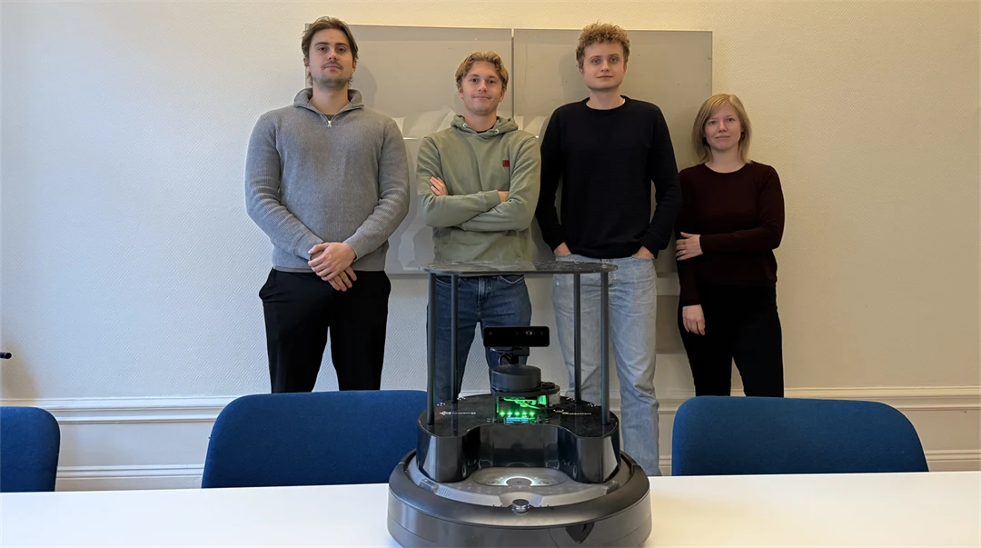 fyra personer framför en robot