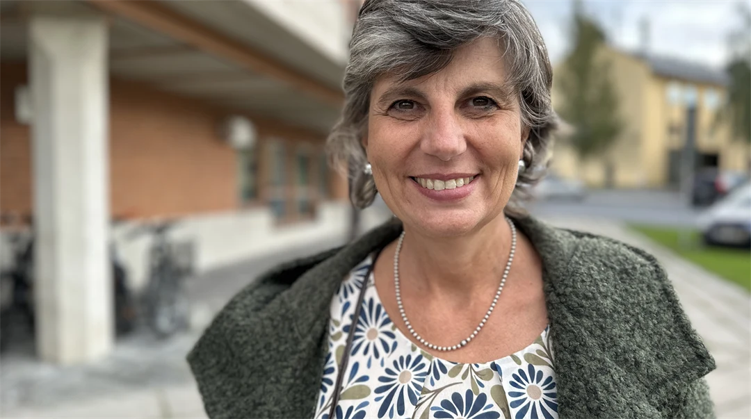 Kvinna i jacka utanför byggnad