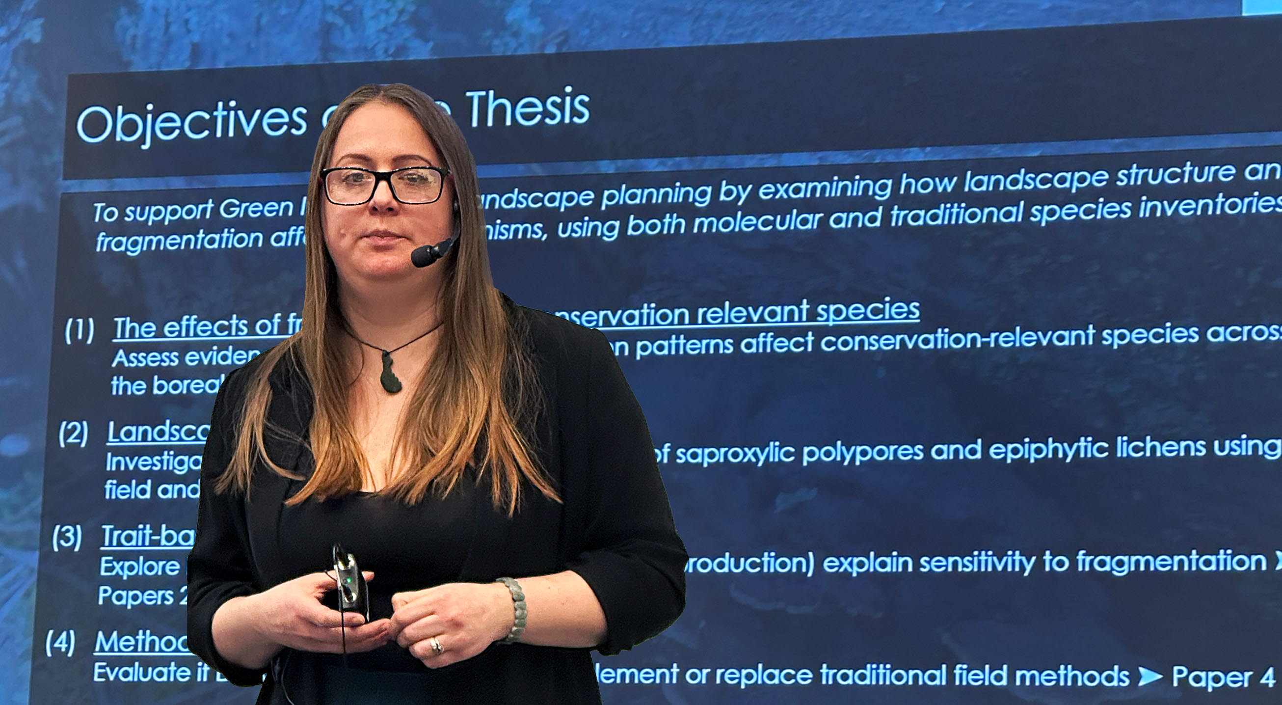 en kvinna med glasögon står framför en powerpointpresenmtation