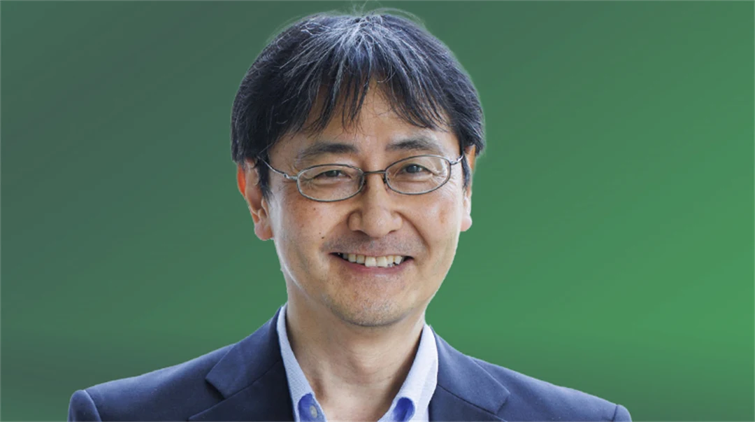 En man tittar in i kameran och ler.