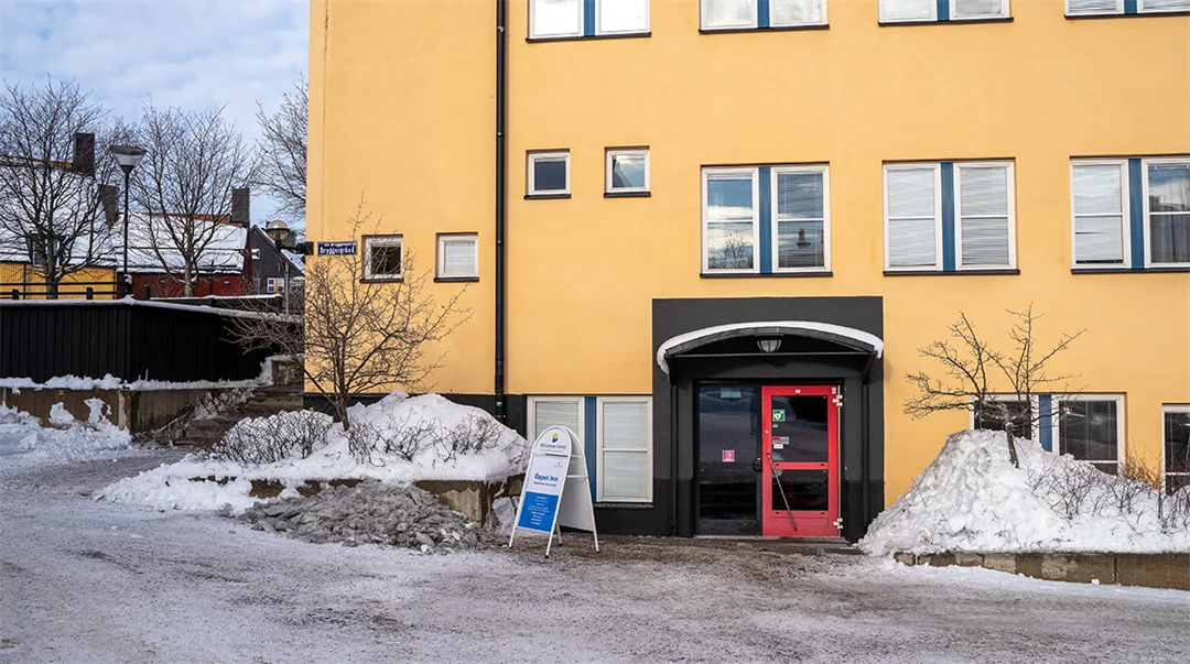 En vit byggnad, en byggnad i glas och en gul byggnad. 