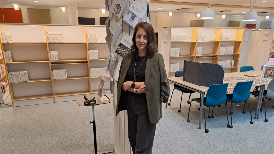 En kvinna med brunt axellångt hår och en grå kavaj