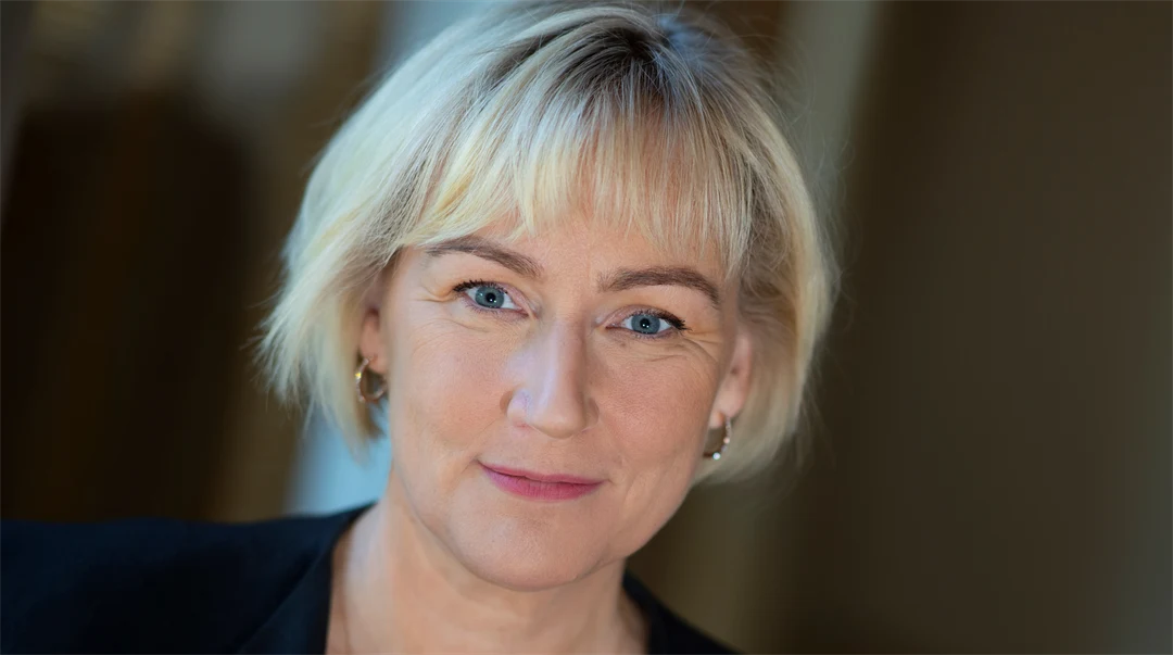 Porträtt av blond kvinna i svart kavaj