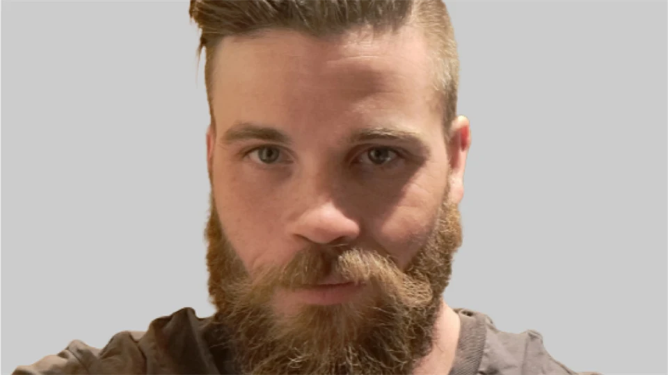 Selfie av ung manlig student från Förvaltningsjuridiska programmet. Han bär brun t-shirt, har helskägg och kort hår.