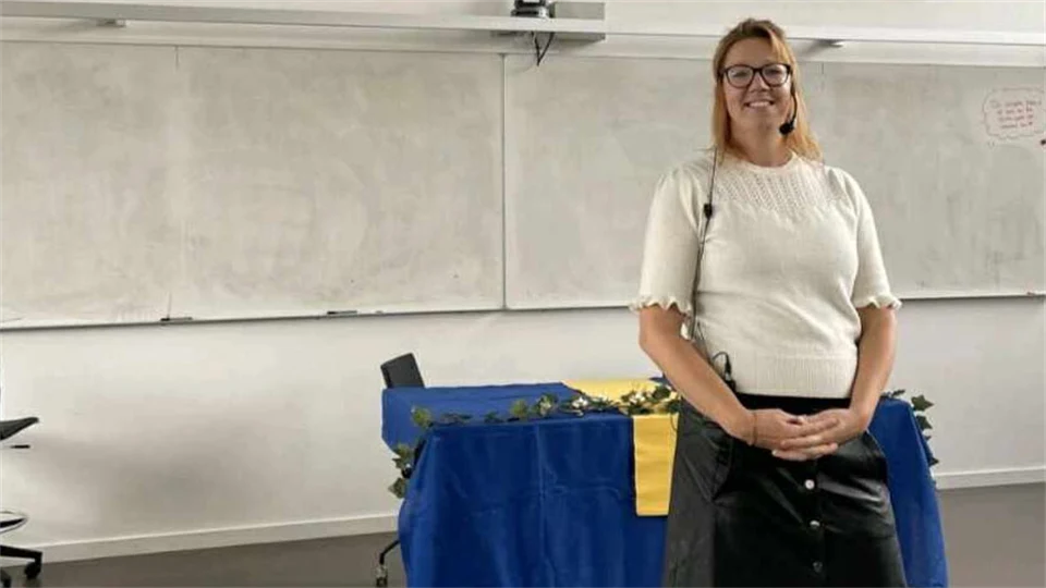 Kvinna med headset står framför bord.