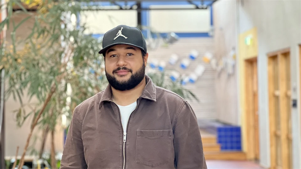 En man med skägg och keps och brun tröja