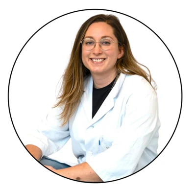 Kvinna med långt mörkt hår, glasögon, klädd i en labbrock.