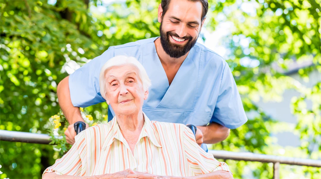 manlig sjuksköterska i samtal med äldre kvinnlig patient