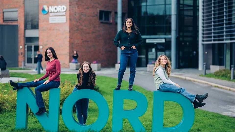 Bokstäverna NORD framför en tegelbyggnad.