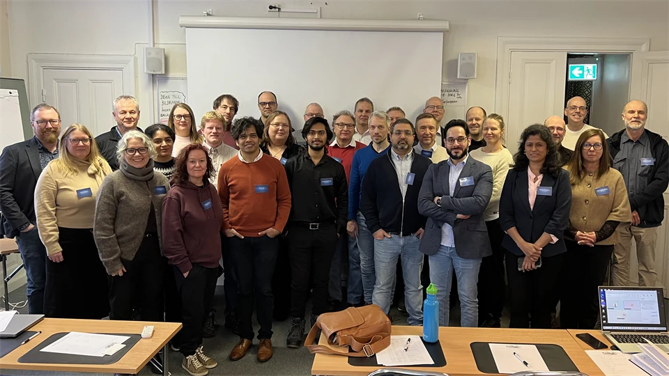 En grupp personer står tillsammans framför en whiteboardtavla.