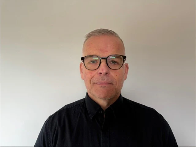 Person som står framför en vit bakgrund