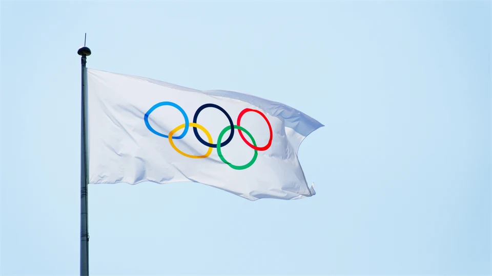 Vit flagga med fem ringar i blått, gult, svart, grönt och rött