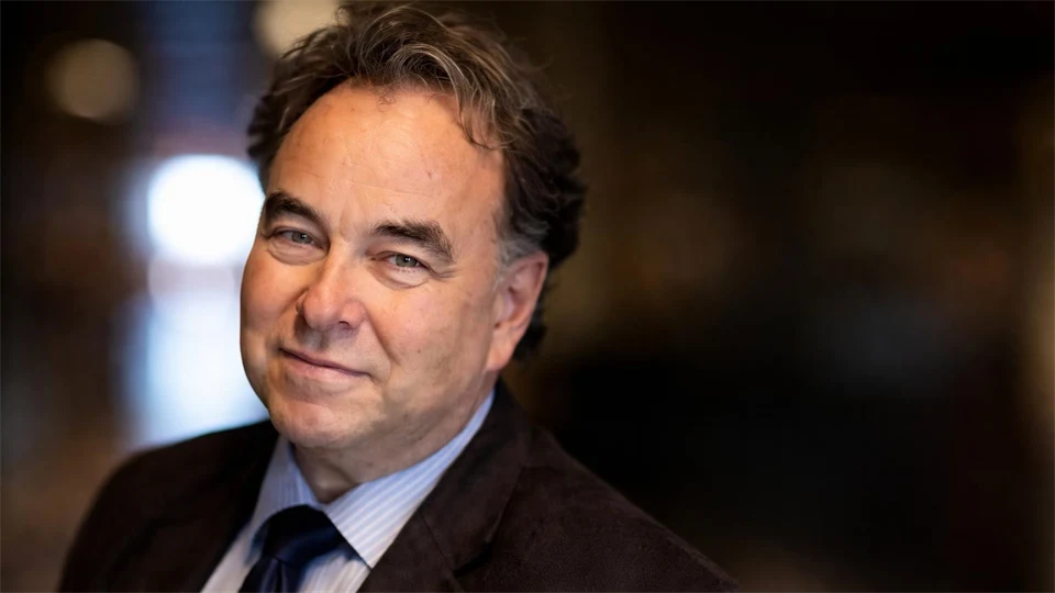 Man med slips och kavaj tittar in i kameran.