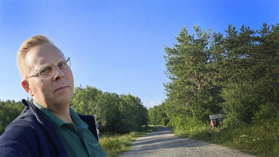 En man står vid en grusväg.