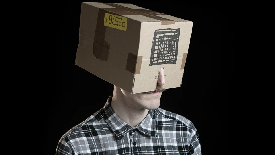 Konstprojekt. Man med kartong på huvudet.