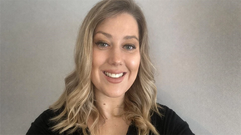 Ung kvinna med utsläppt långt hår iklädd svart tröja.