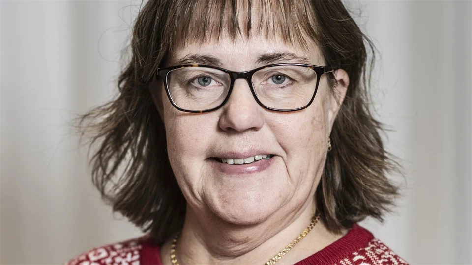 En kvinna med mörkt hår och glasögon