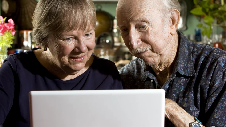 Pensionärer framför dator