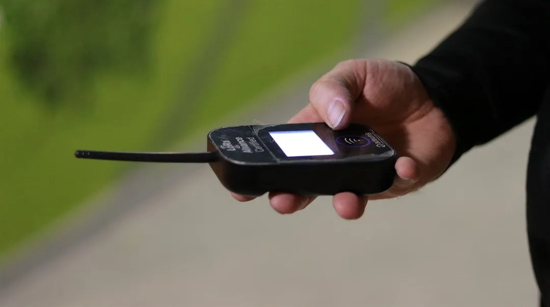 A hand is holding a signal receiver.