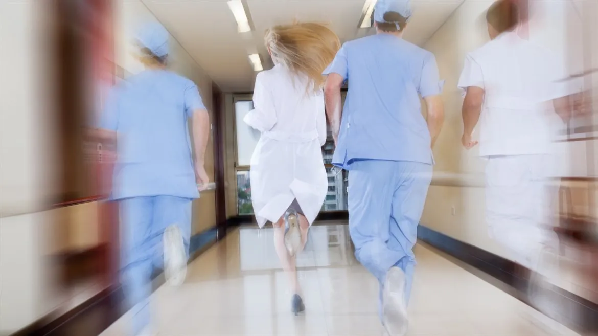 Sjukvårdspersonal springer i sjukhuskorridor