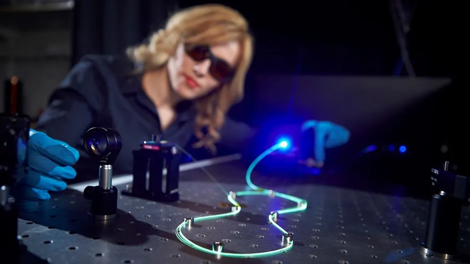 Enkeleda Balliu working with laser and fiber optic in the lab