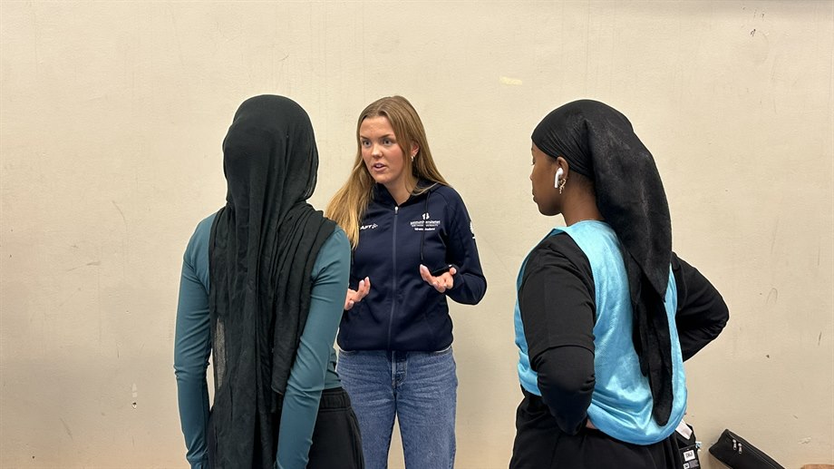 Studenten Elsa Bergh pratar med fotbollsstjejerna i SDFF Plus.