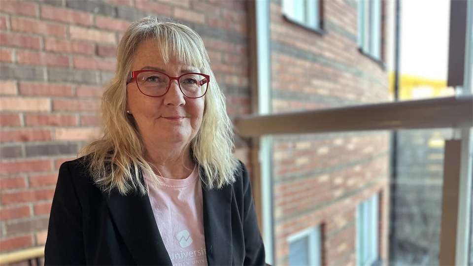 En kvinna står framför ett fönster