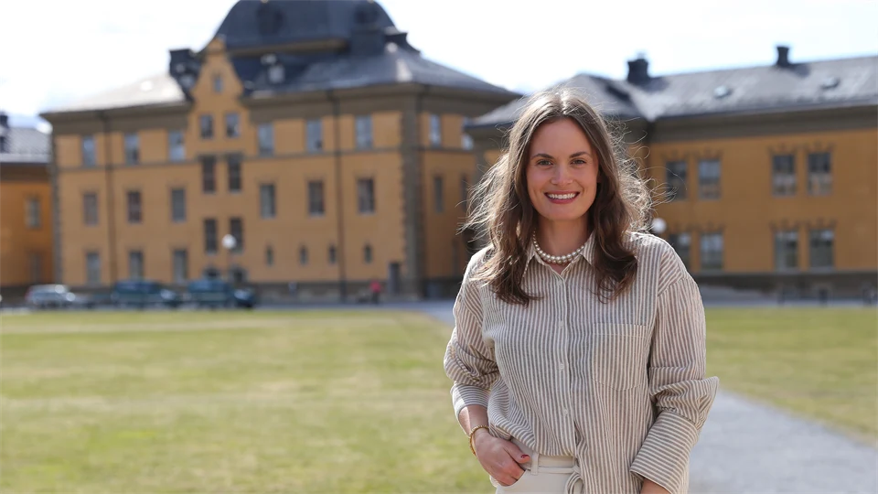 Kvinna utomhus med byggnader i bakgrunden.