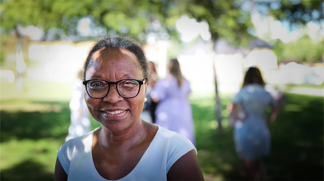 En kvinna tittar in i kamen och ler. 