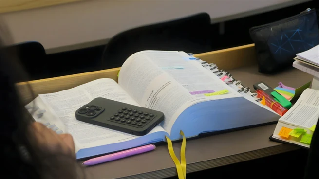 Vältummad lagbok ligger på en skolbänk i en skolsal