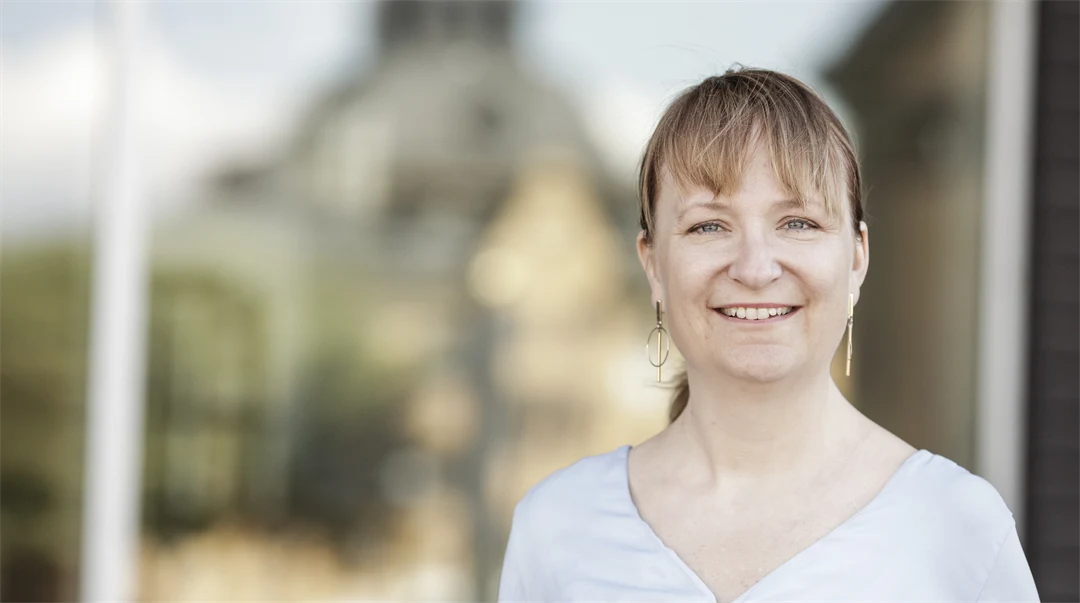 Porträttbild på kvinna i ljusgrå tröja