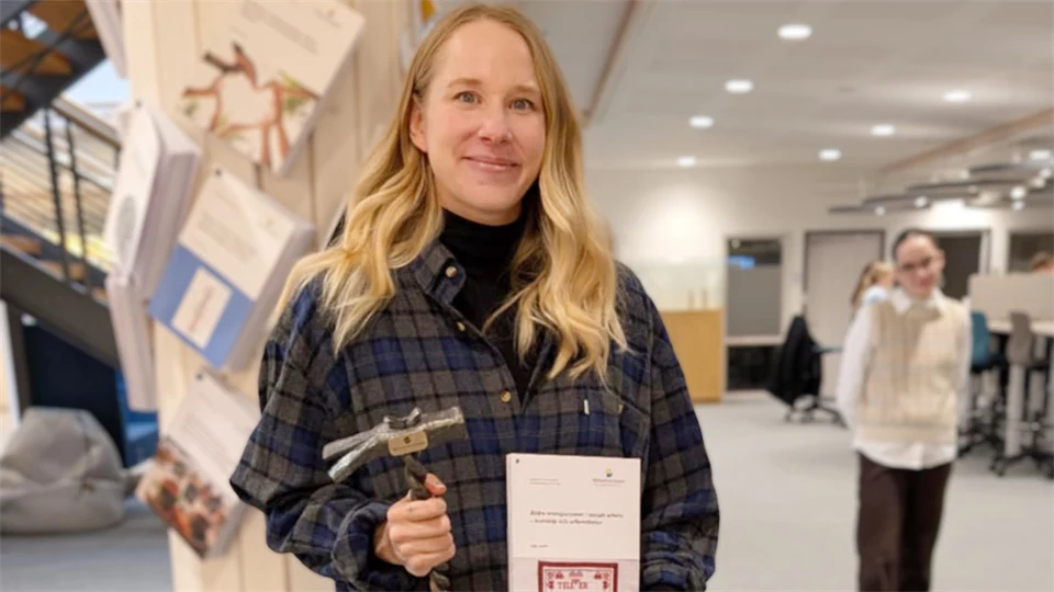 Kvinna som håller i bok och hammare