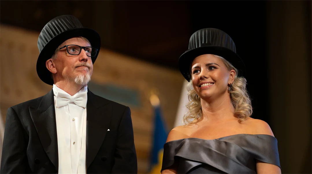 Två finklädda personer som bär varsin doktorshatt.