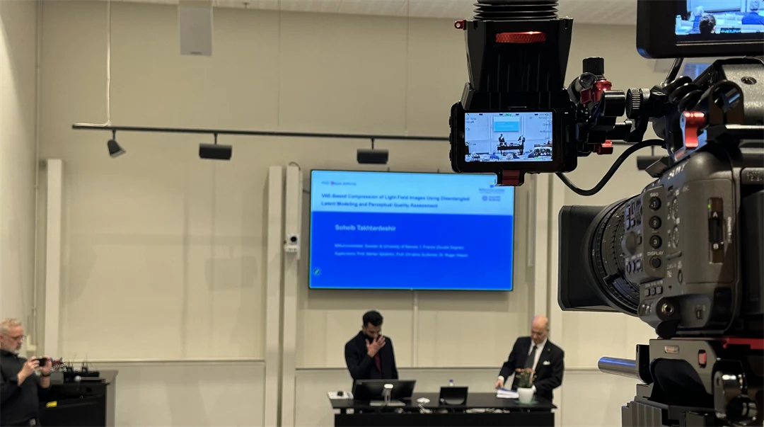 A camera whos filming two people on a stage