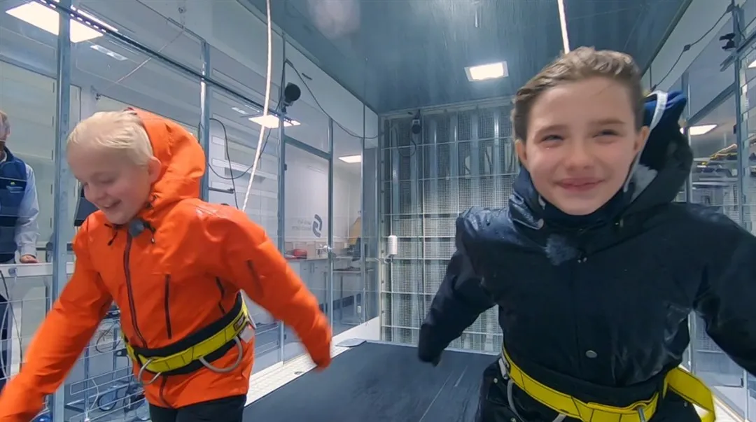 Barn testar vattentäthet i friluftsprodukter