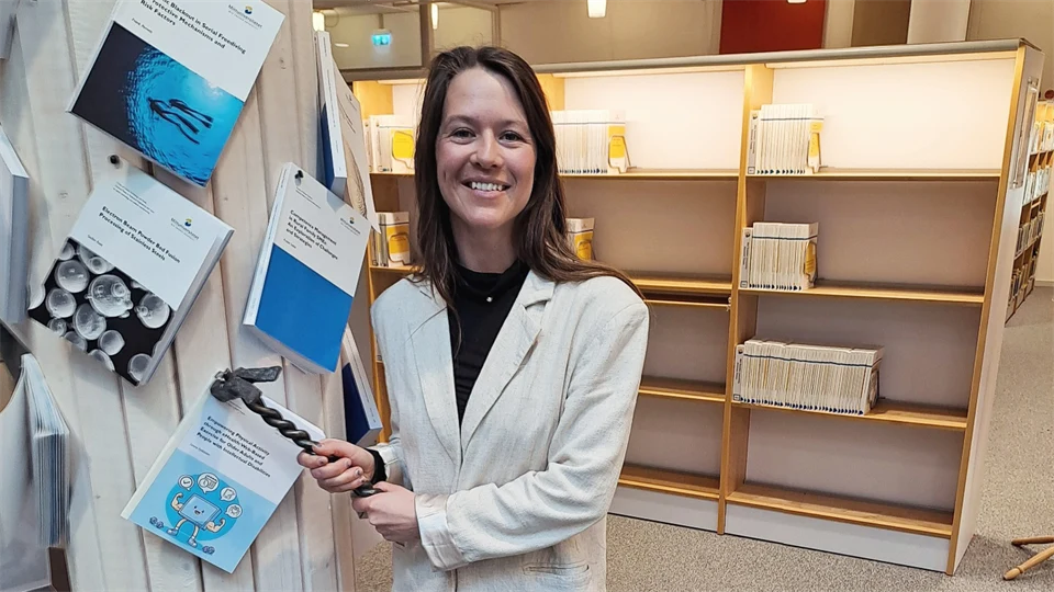 Kvinna spikar fast bok på en stolpe